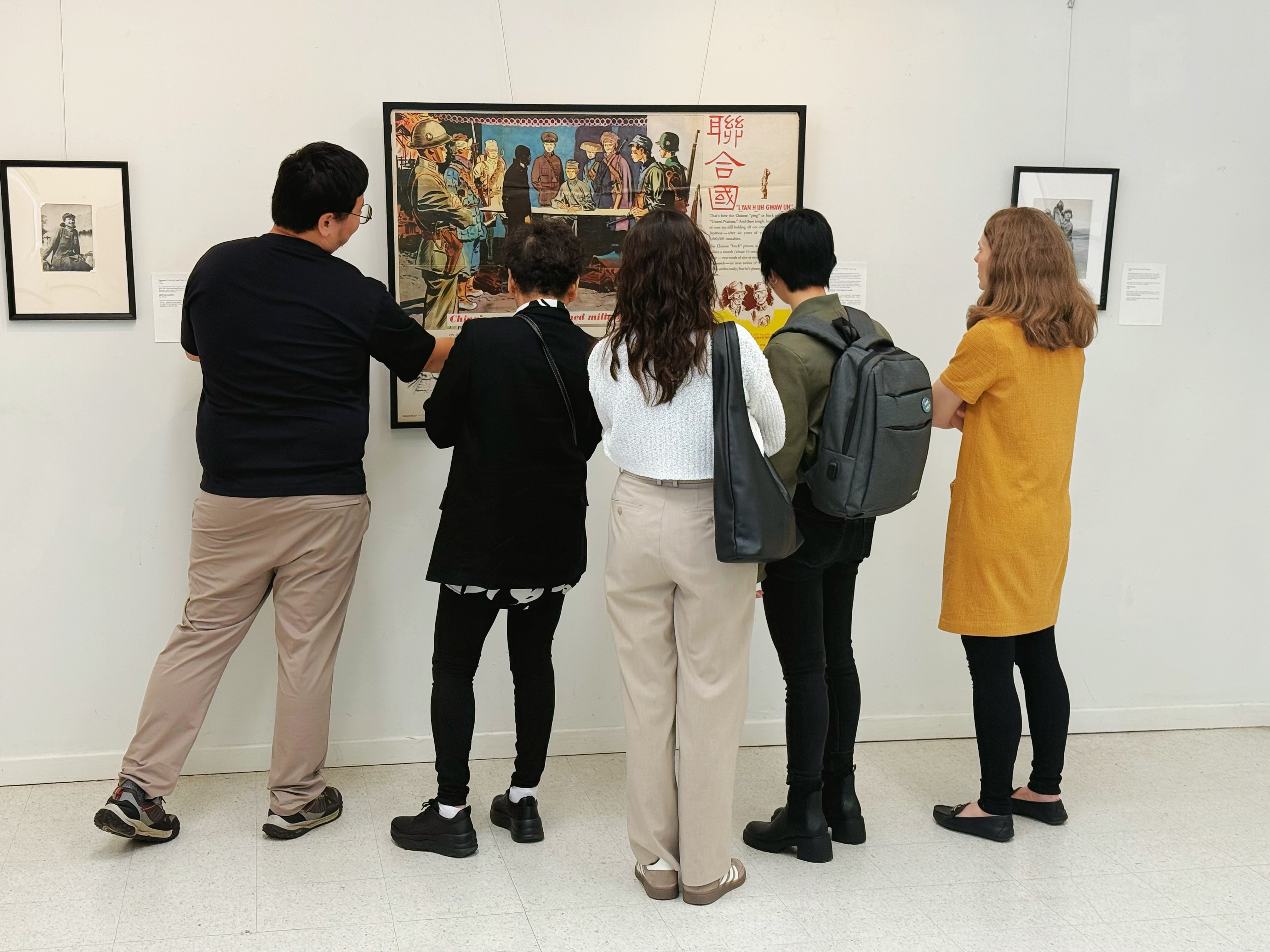 A guided group viewing a wartime poster and exhibition text.