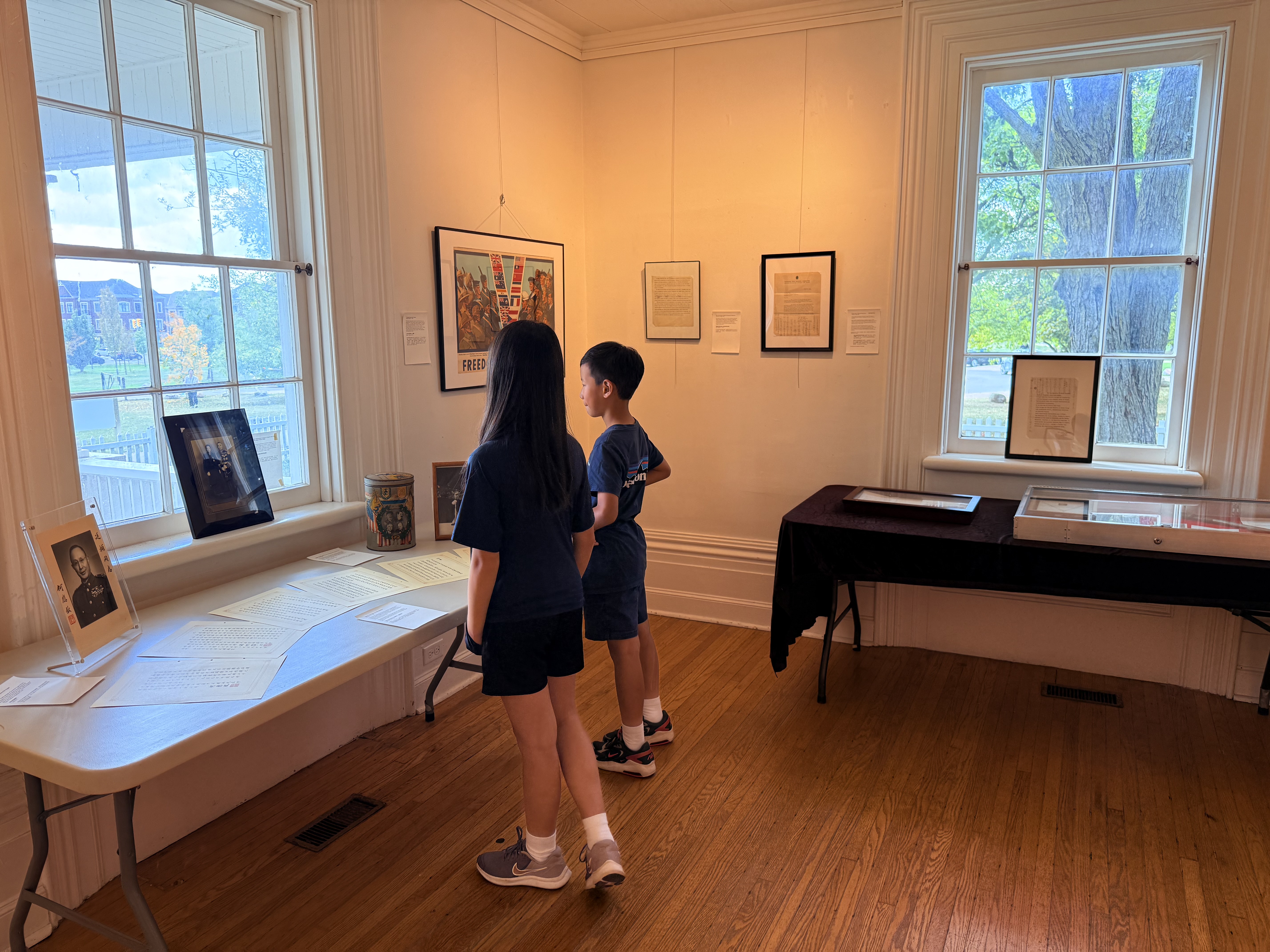 Young visitors viewing MOFER exhibition materials at Boynton House.